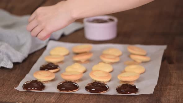 Female Chef Decorating Cookies with Melted Chocolate