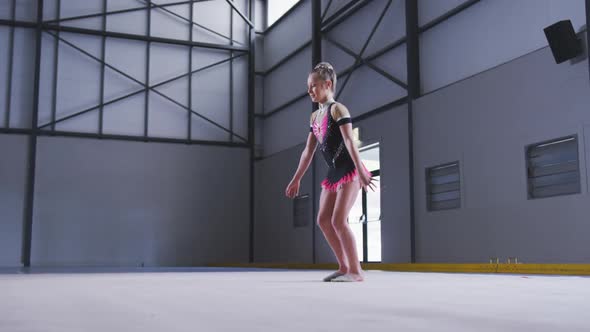 Teenage female gymnast performing at sports hall