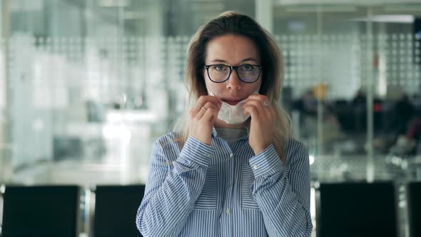 Woman's Face with Glasses and a Medical Mask in a Close Up