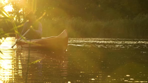 Cowboy in a Canoe Floats on the River