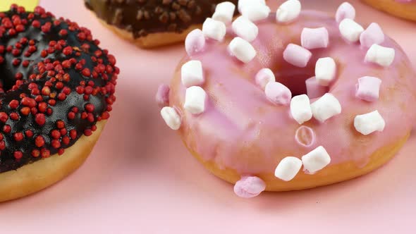 Close-up slider motion donuts. 4k closeup of delicious sweet multicolored donuts