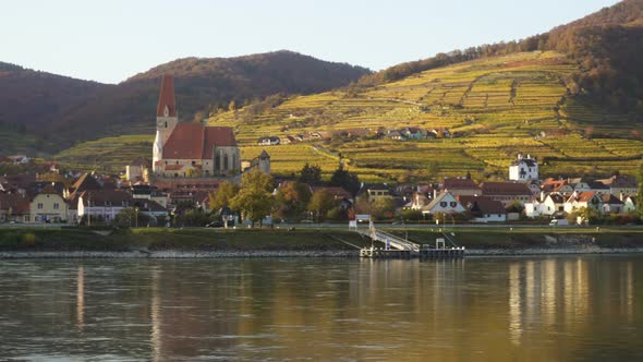 Autumn View Of Small Austrian Village On A River Bank