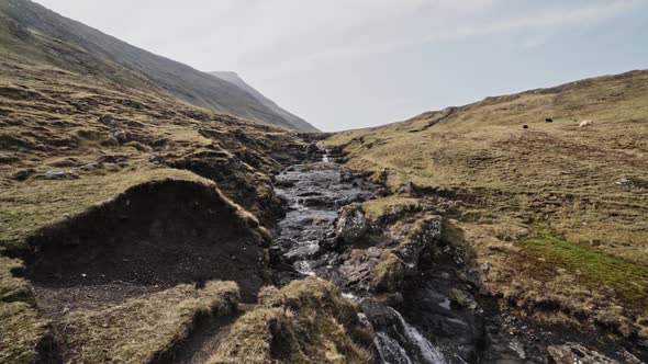 Rocky Stream in Between Cliffs Located in Faroe Islands on a Sunny Day