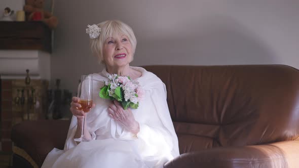 Gorgeous Elegant Senior Woman in White Wedding Dress with Bridal Bouquet Smiling Toasting Stretching