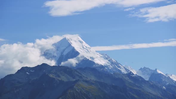 Ice capped Mount Cook Summit; time lapse withing clouds on a sunny day. Aoraki.