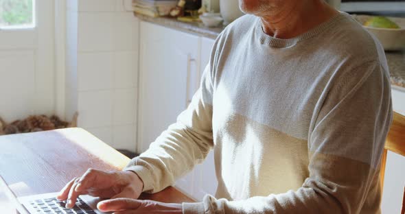 Senior Man Using Laptop in Kitchen 4k