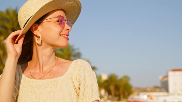 Happy girl with hat in summer city