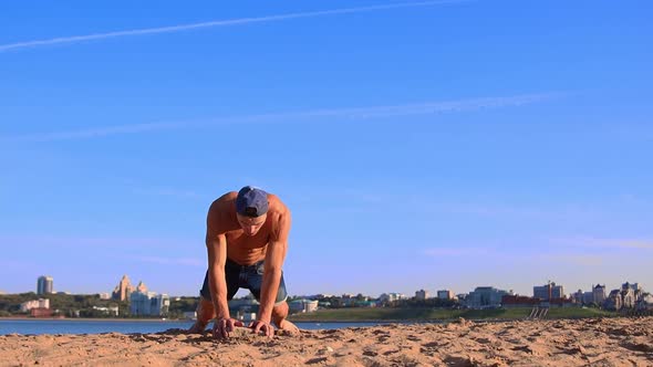 Young Fit Man Doing Sports Exercises at the Beach While Sunny Summer Day