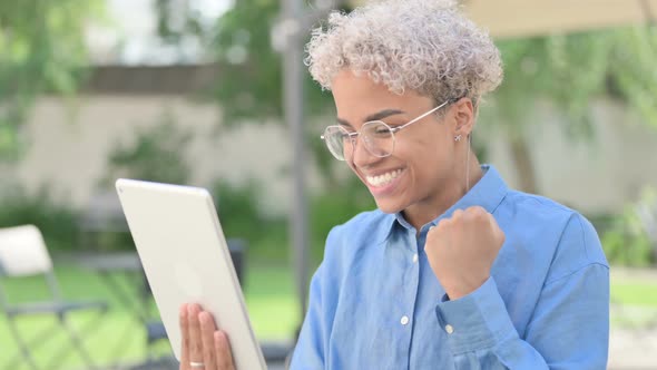 Portrait of Young African Woman Celebrating on Tablet