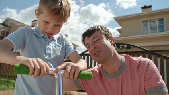 Father Teaching Son How to Fix Scooter