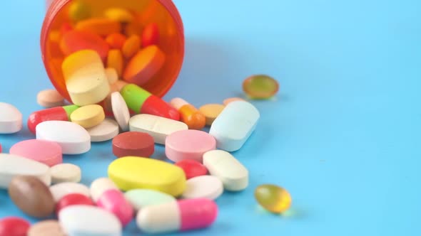 Close Up of Many Colorful Pills and Capsules on Blue Background