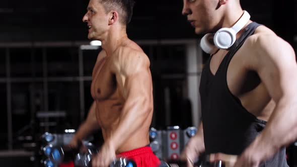 Two Fit Handsome Men Pumping Their Hands Looking in the Mirror in the Gym