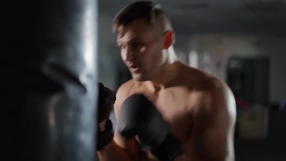 Handsome Confident Caucasian Boxer Boxing Punching Bag in Gym Indoors