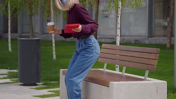 Business woman takes a break from work and sits on a bench