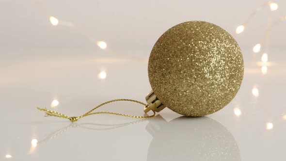 Close-up of golden  bauble with sequins 4K 2160p 30fps UltraHD tilting  footage - Round Christmas or