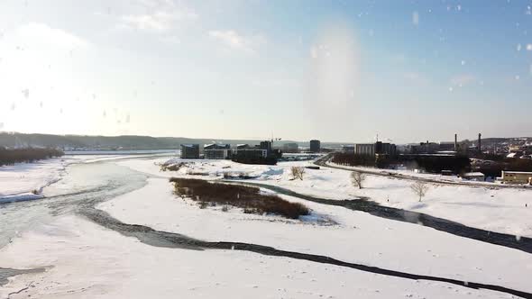 Frozen Neris river and new apartment building district in Kaunas city on sunny snowing day