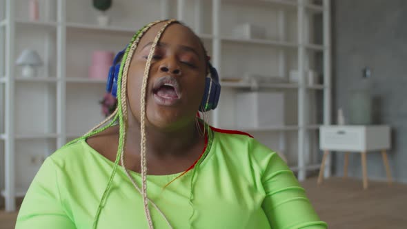 Black Woman in Headphones Enjoying Music at Home