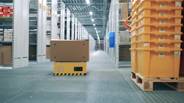 A Robot is Crossing the Warehouse with a Package on Its Back