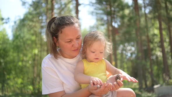 Little Cute Baby Toddler Girl Blonde with Curls on Mother's Arms