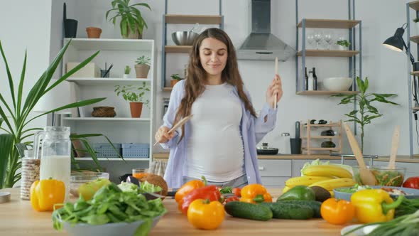 Happy Pregnant Woman Dancing in the Kitchen in the Morning