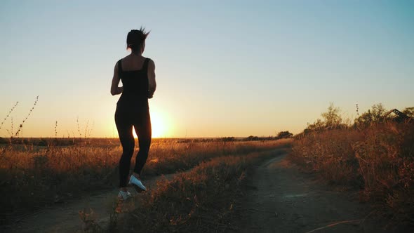 Young Fitness Sport Woman Running on Road at Sunset. Athlete Runner Feet Running on Road, Slow