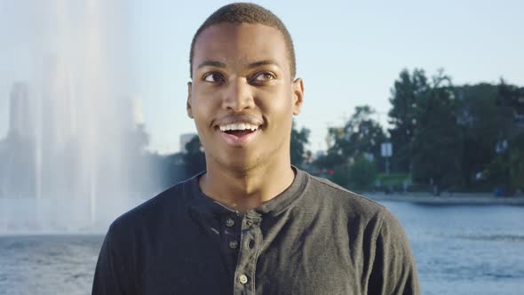 Young African American Man Standing in Front of Camera and Laughing