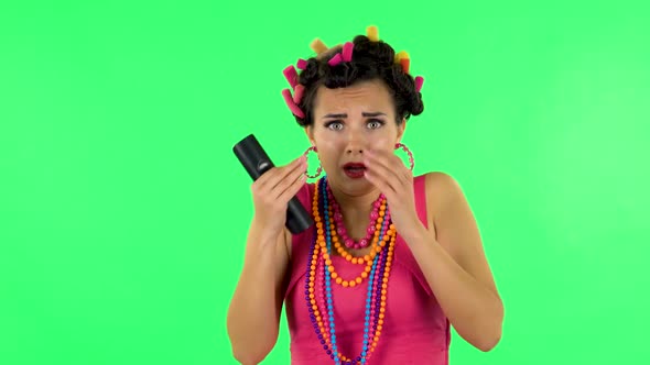 Woman with TV Remote in Her Hand, Switching on TV Bored and Is Very Scared. Green Screen