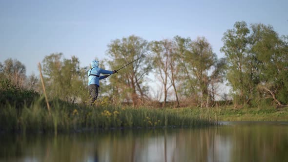 The Fisherman Sportsman Catches a Predatory Fish on a Spinning on the Lake