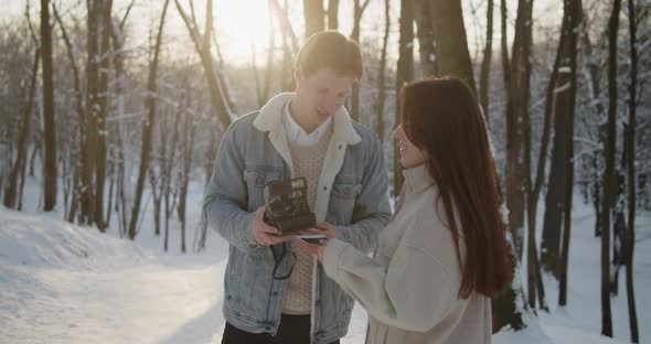 Happy Young Beautiful Couple Spend Time in Sunny Winter Forest Together
