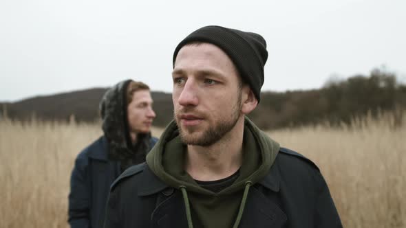 Two Young Guys Standing In Field. Stylish Young Friends.