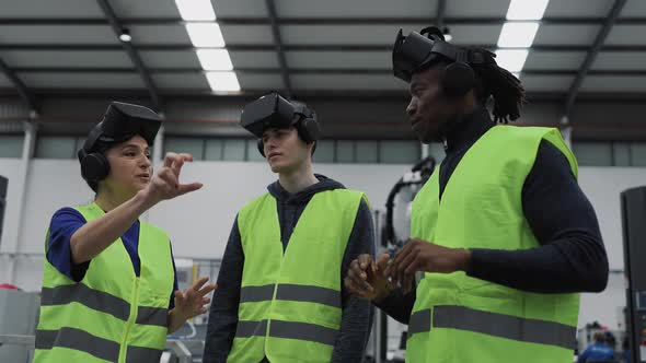 Team of engineers having simulation experience with virtual reality glasses in robotic factory