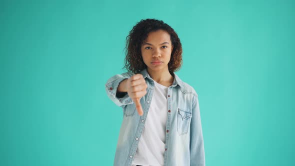 Portrait of African American Lady Stretching Arm Forward Showing Thumbs-down