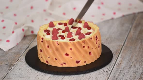 Cutting a Raspberry Mousse French Dessert