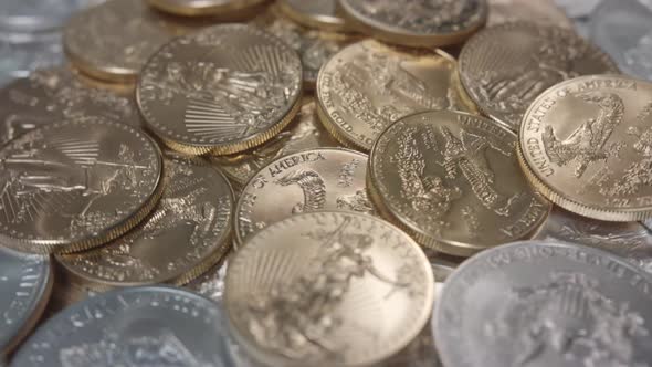 American Gold Eagles coins on a pile of silver coins spinning left