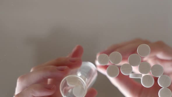 Woman Puts the Pills in a Bottle, Close-up.