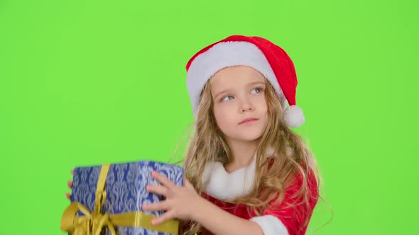 Child Holds a Gift Box in His Hands and Smile. Green Screen