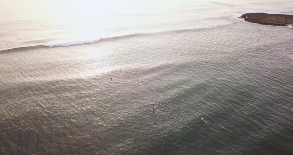 Drone shot of a beach on the North Shore of hawaii. Surfers chilling on the water waiting for waves