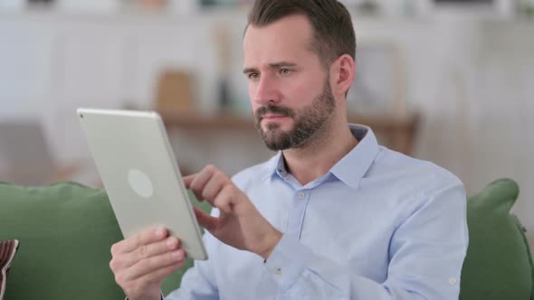 Young Man Facing Loss on Tablet