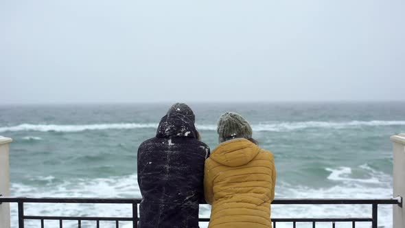 Portrait From Back of Young Hipster Couple Man and Woman Looking at Water and Waves While Dating in