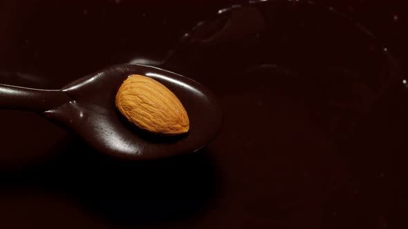 Melted Liquid Premium Dark Chocolate and Almond Rotating Process of Making Sweet Desserts with Nuts