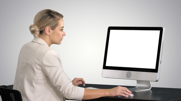 Young woman working in office sitting at desk, looking