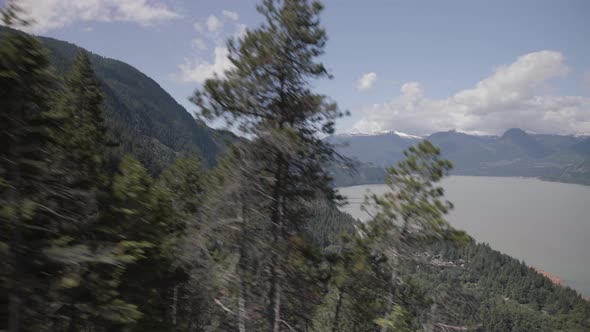 Elevated View of spring Howe sound from Gondola, fast moving trees in foreground