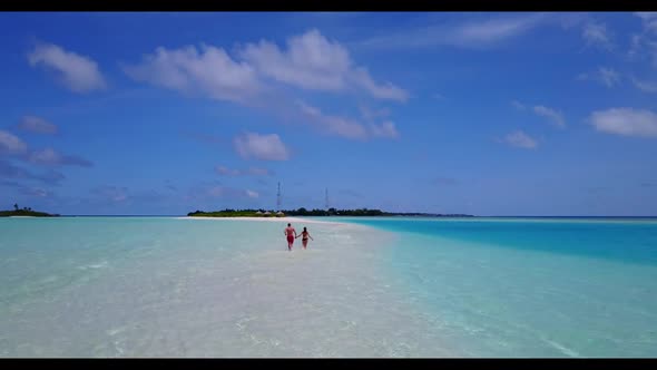 Two lovers sunbathe on exotic coastline beach lifestyle by blue green ocean and white sandy backgrou