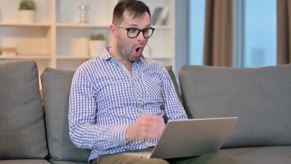 Young Man Feeling Shocked Using Laptop at Home 