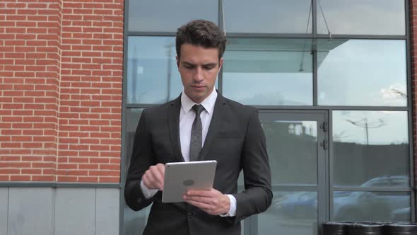 Businessman Using Tablet for Browsing Standing Outside Office