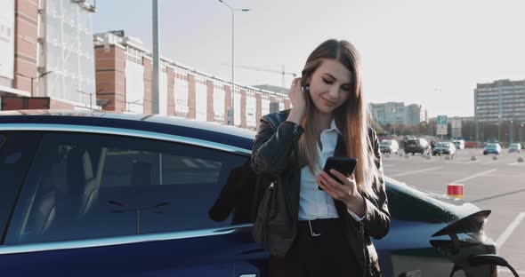 European Woman Use Smart Phone While Waiting and Power Supply Connect To