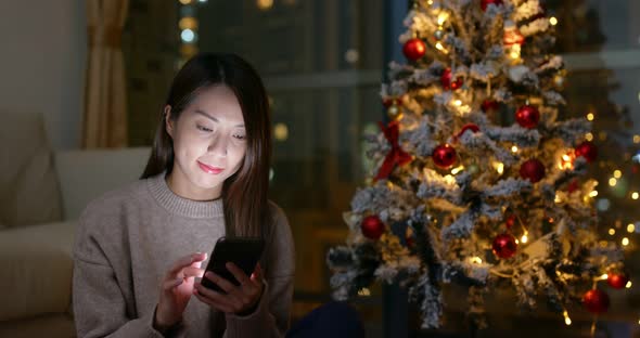 Woman use of cellphone at Christmas decoration