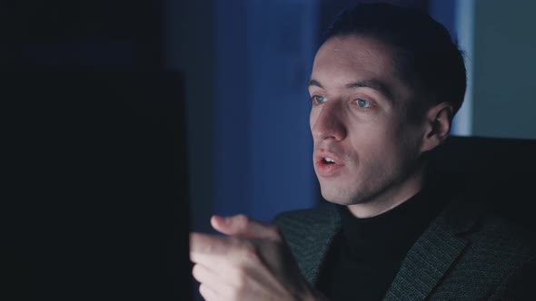 Smiling Young Man Entrepreneur Making Video Call While Sitting at Computer Laptop Late at Night