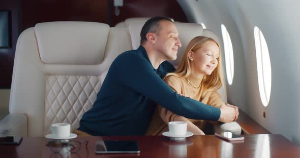 Happy Middleaged Couple Laughing and Enjoying View in Airplane Window