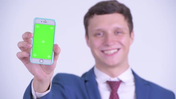 Face of Happy Young Businessman Showing Phone